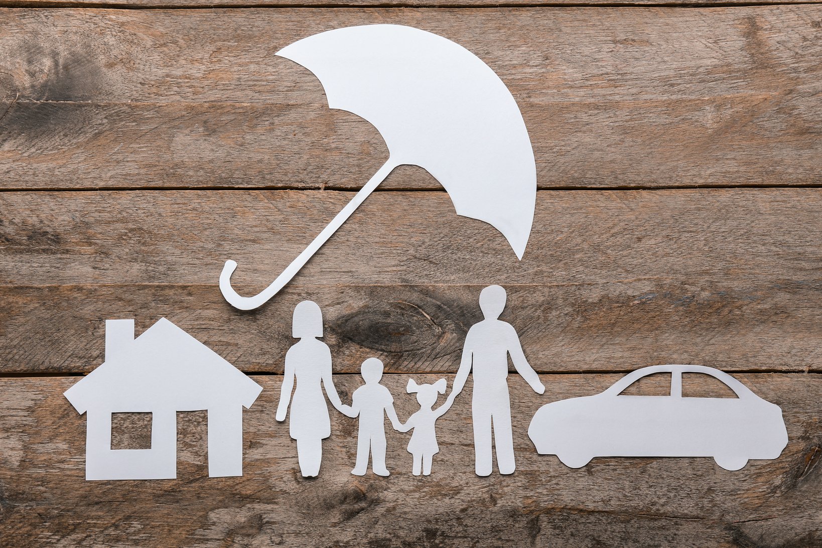 Cutout of Family, Umbrella, House and Car on Wooden Background